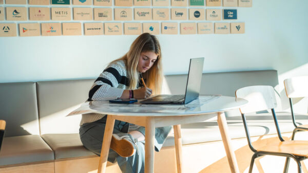 Young woman studying or working on a laptop at a startup office in Belgium